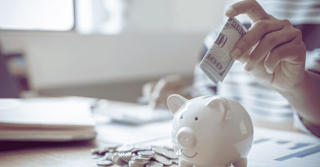 Placing money in a piggy bank to start getting ahead financially