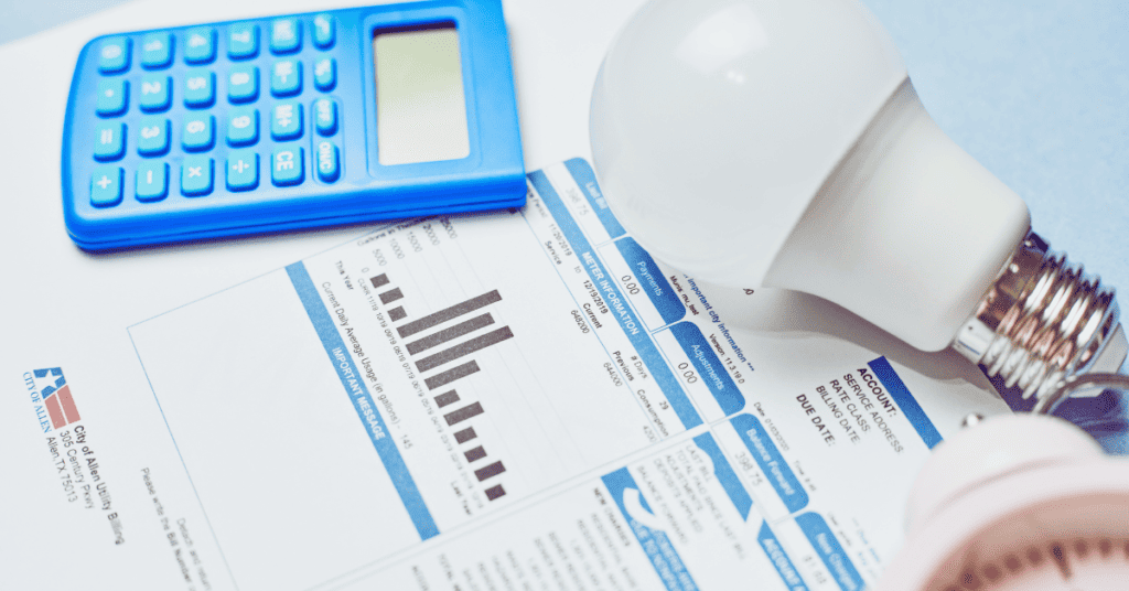 A calculator, light bulb, clock, and some utility bills